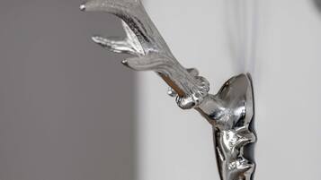A silver deer antler ornament hanging from a ceiling.