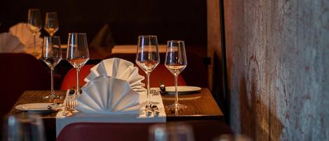 A restaurant setting with tables set for dining, including plates, glasses, and cutlery.