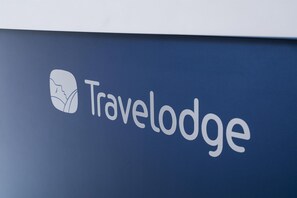 A logo with the word "Travelodge" and a stylized face icon.