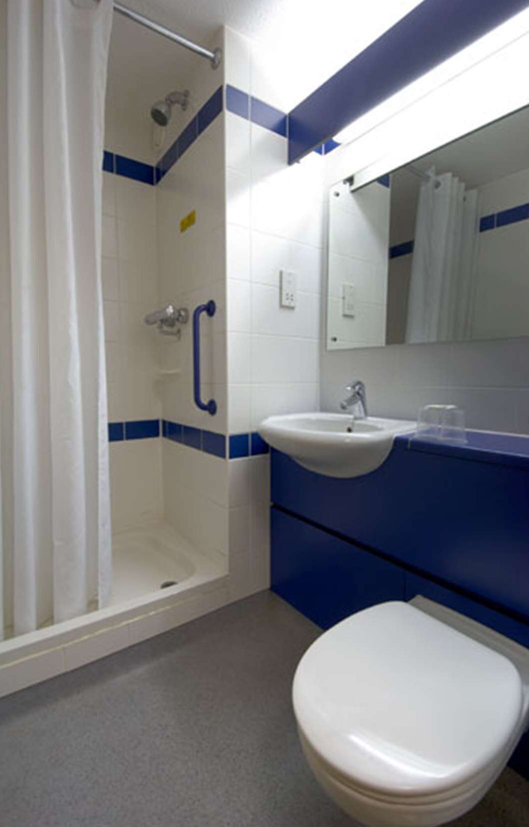 Un baño con ducha, lavamanos e inodoro.