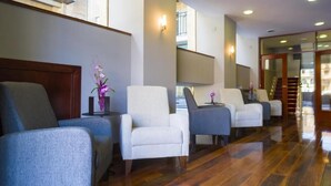 A hotel lobby with a reception desk, a seating area with four chairs, and a wooden floor. - Soho Boutique Salamanca  (Salamanca)