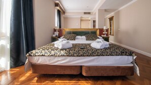 A large bed with a patterned bedspread, two pillows, and two towels. - Soho Boutique Salamanca  (Salamanca)