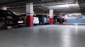 A multi-level parking garage with cars parked under concrete pillars.