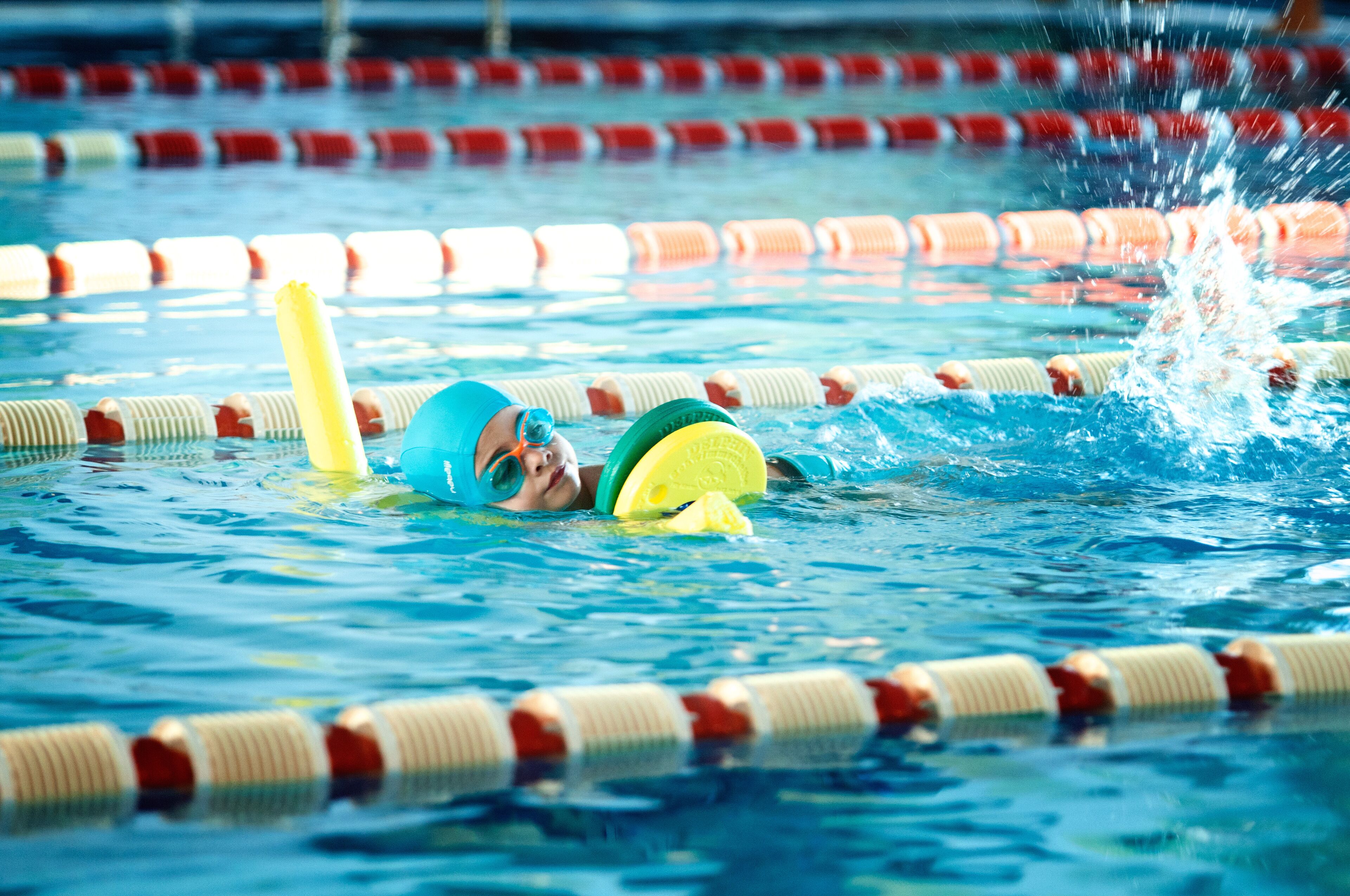 Ein Schwimmbecken mit Bahnen und einer Schwimmerin im Wasser.