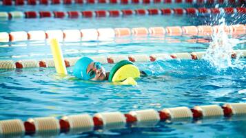 Ein Schwimmbecken mit Bahnen und einer Schwimmerin im Wasser.