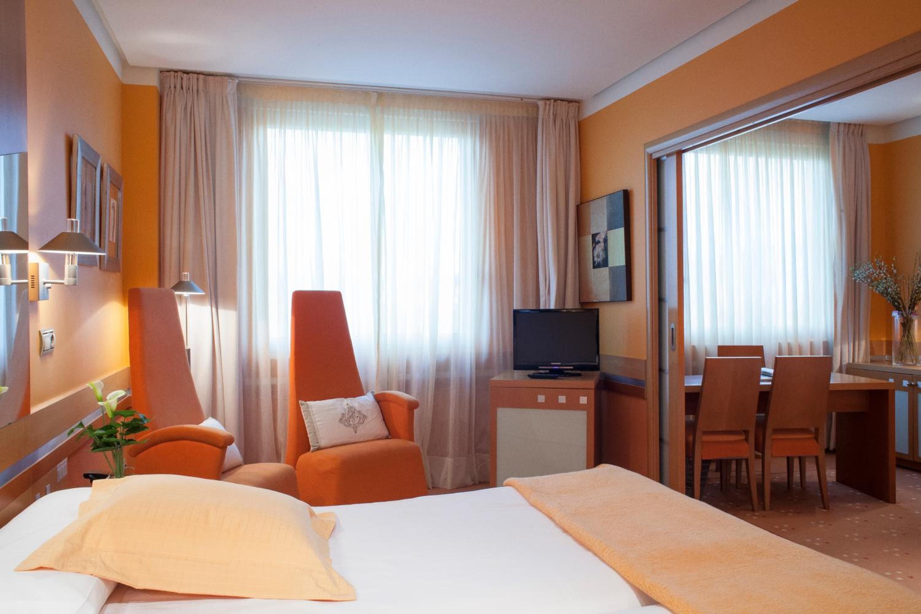 Une chambre d’hôtel comprenant un lit, un bureau, une télévision et un coin repas.
