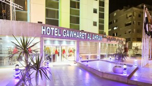Das Hotel Gawhareet Al Ahram mit gut beleuchtetem Eingang, Blumentöpfen und modernem architektonischen Design.