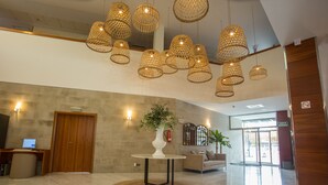 A spacious lobby with a round table, a wooden desk, a sofa, and a large window. - Hotel Alaquas (Alaquas)