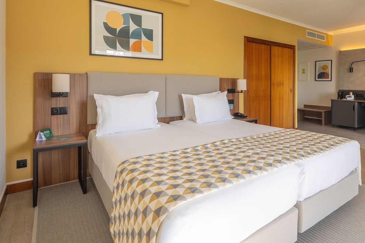 Habitación de hotel con una cama grande, un escritorio y una silla.