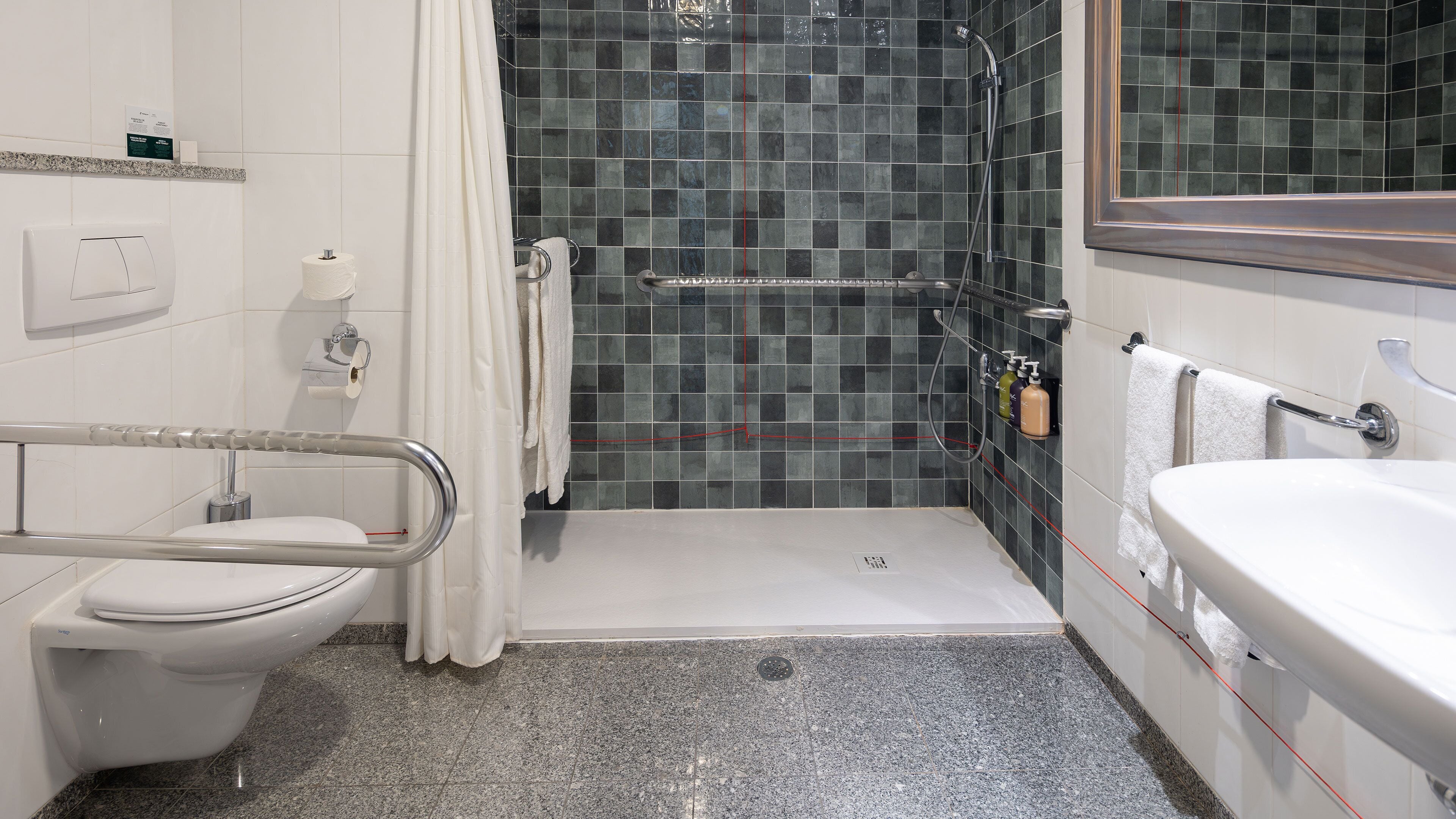 A modern bathroom with a shower, toilet, and sink.