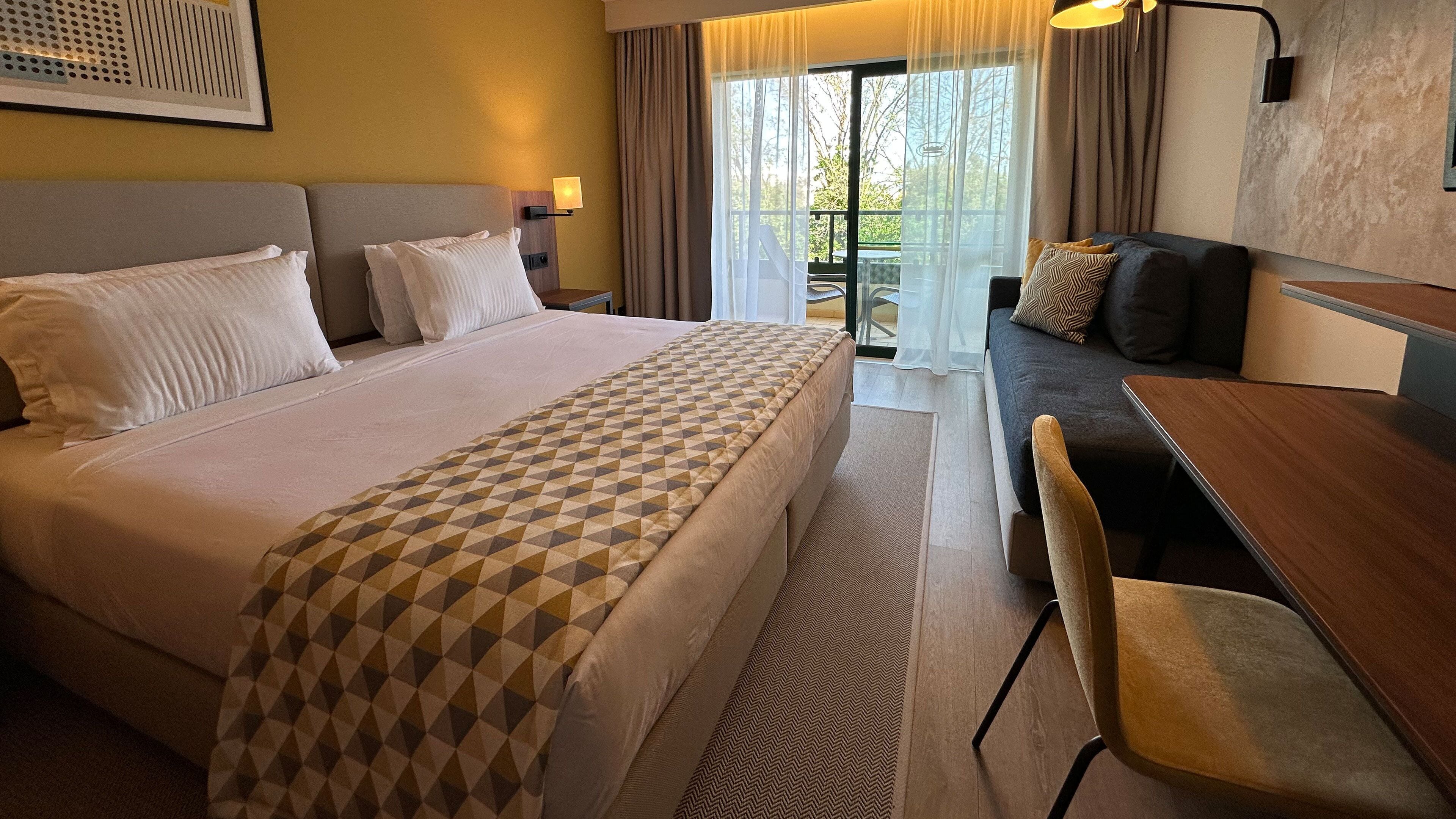 Une chambre d’hôtel avec un grand lit, un canapé, une table à manger et une chaise.