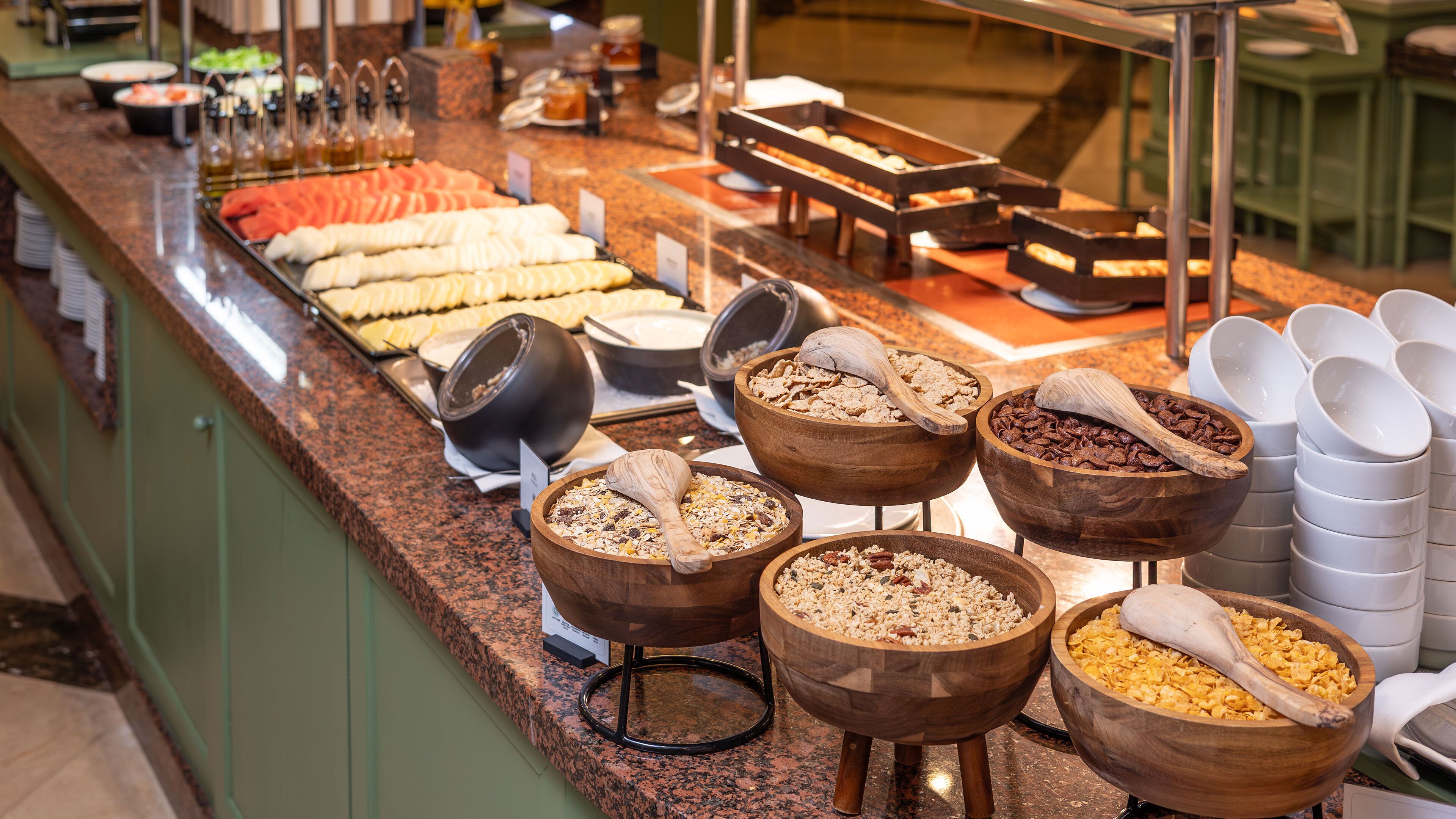 Un buffet proposant une variété de plats et des bols de céréales.