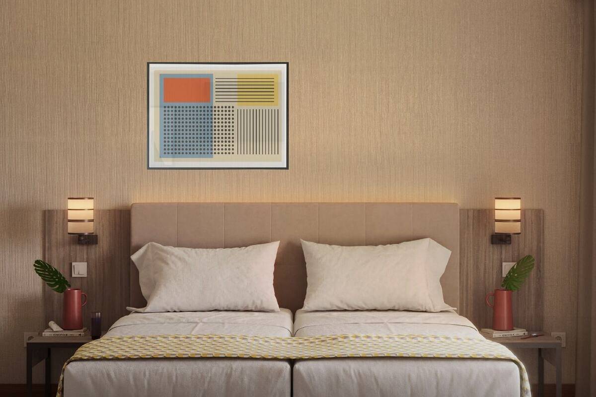 Habitación de hotel con una cama grande, dos mesitas de noche con lámparas, una obra de arte abstracta enmarcada en la pared y una planta en maceta sobre cada mesita.