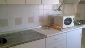 Eine Küche mit weißen Schränken, einer Mikrowelle und einem Toaster auf der Arbeitsfläche.