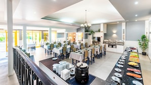 A spacious dining area with multiple tables and chairs, a buffet line with various food items, and a kitchen area in the background. - Hotel Pinhal do Sol (Loulé)