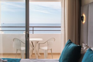 A hotel room with a balcony, a bed, a table, two chairs, and a view of the sea. - Hotel Atismar (Loulé)