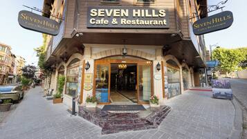 A building with a sign reading 'SEVEN HILLS Cafe & Restaurant' at the entrance.