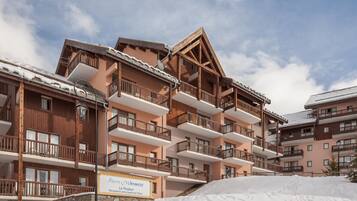 A multi-story hotel with wooden balconies and a sign indicating it is a vacation rental.