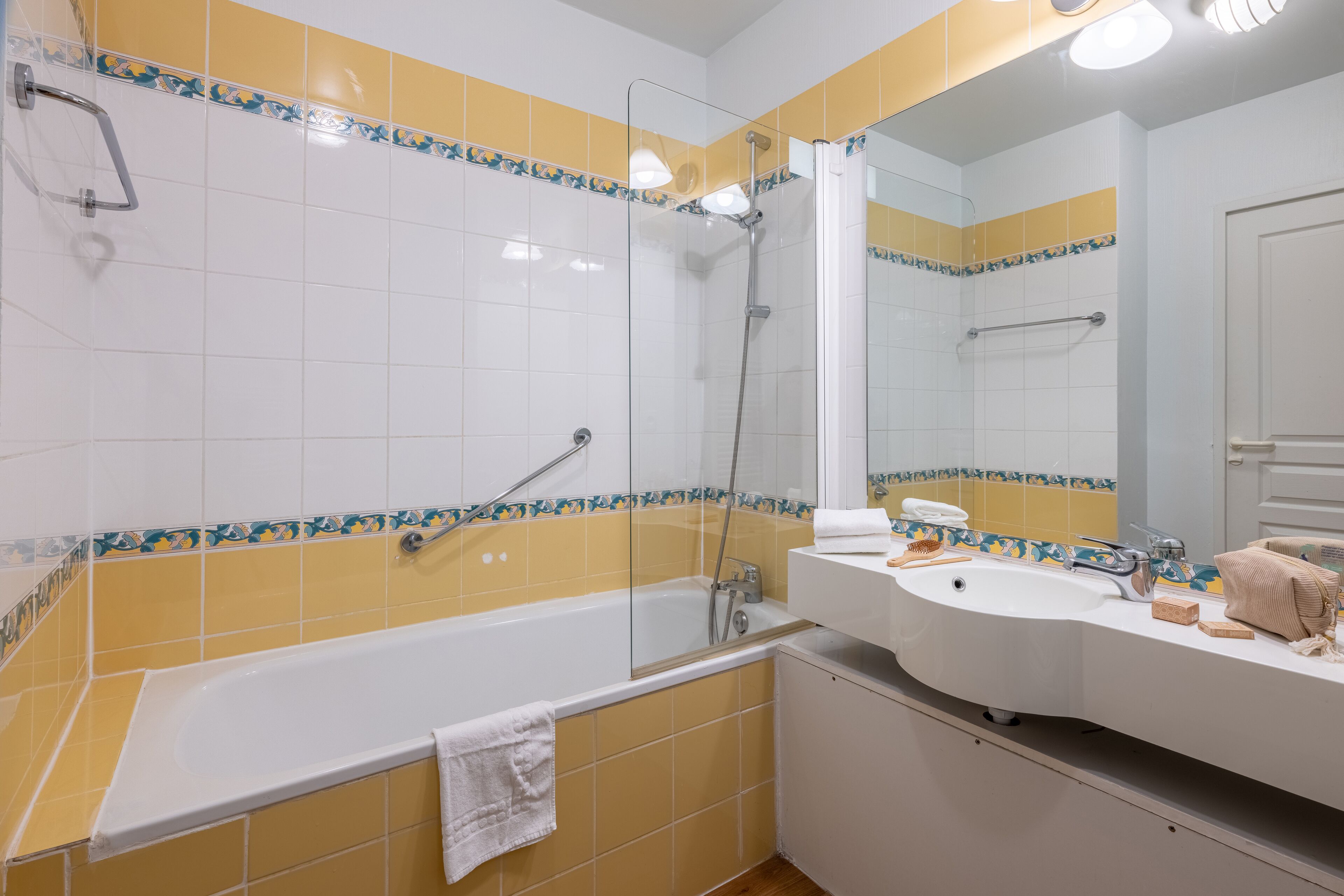 Une salle de bain avec une baignoire, une douche, un lavabo et un miroir.