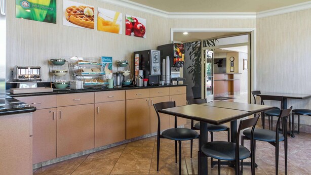 Un espace dédié au petit-déjeuner, comprenant un comptoir, des machines à café et des sièges.