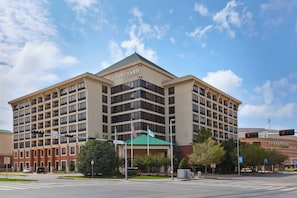 A multi-story hotel with a prominent "Courtyard" sign, featuring a green roof and multiple windows. - Courtyard by Marriott Oklahoma City Downtown (Oklahoma City)
