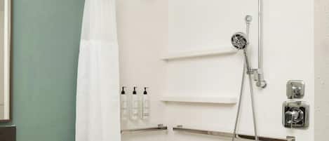 A bathroom with a shower, a toilet, and a sink.