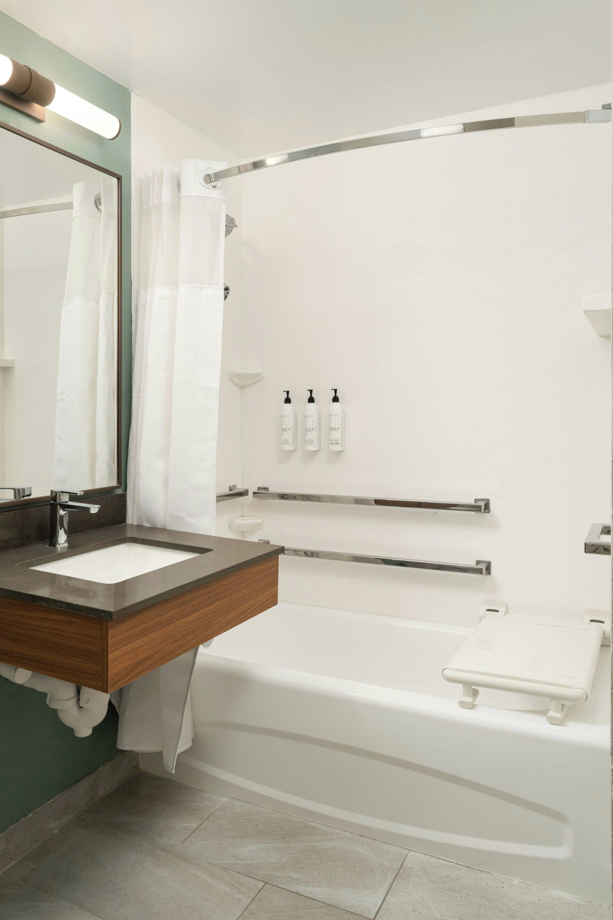 Une salle de bain moderne avec un meuble-lavabo en bois, une baignoire blanche et une cabine de douche en verre.