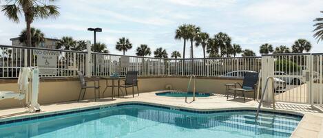 A pool area with a 'NO DIVING' sign, pool lift, and lounge chairs.
