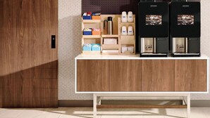 Eine moderne Küche mit einem Holzkasten, einer Kaffeemaschine und einem Wasserkocher.