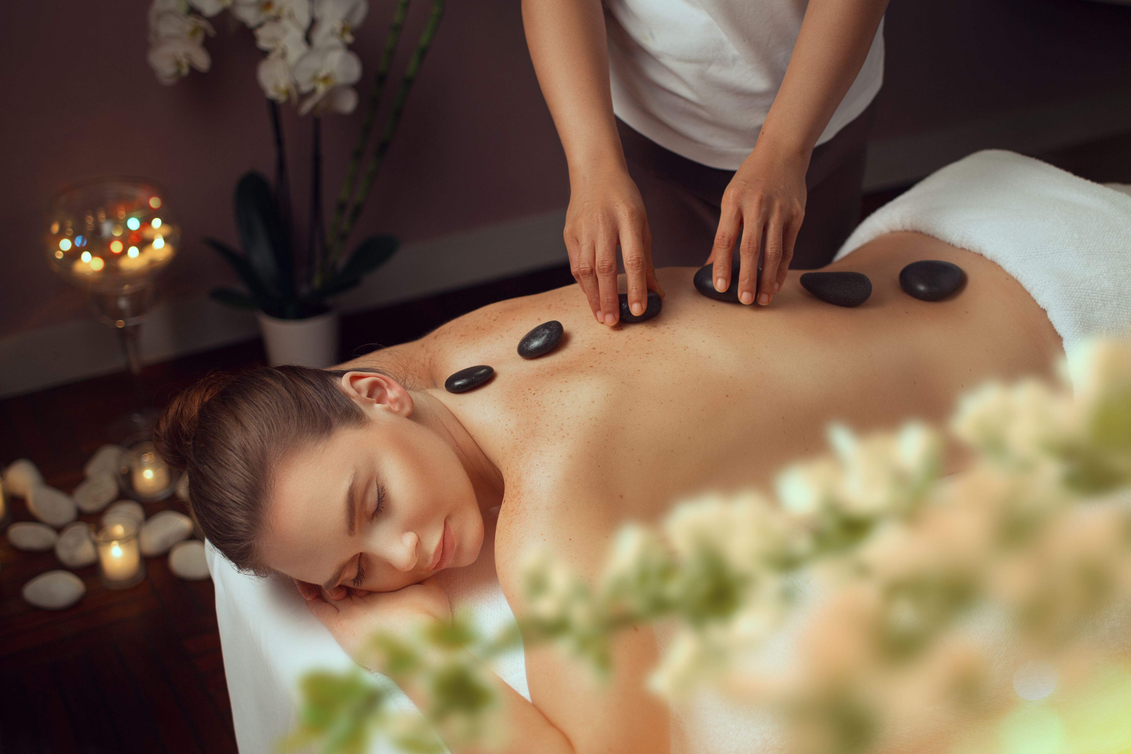 A person receiving a stone massage.
