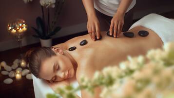 A person receiving a stone massage.