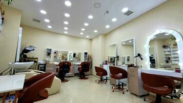 A well-lit salon with multiple mirrors, chairs, and a vanity area.