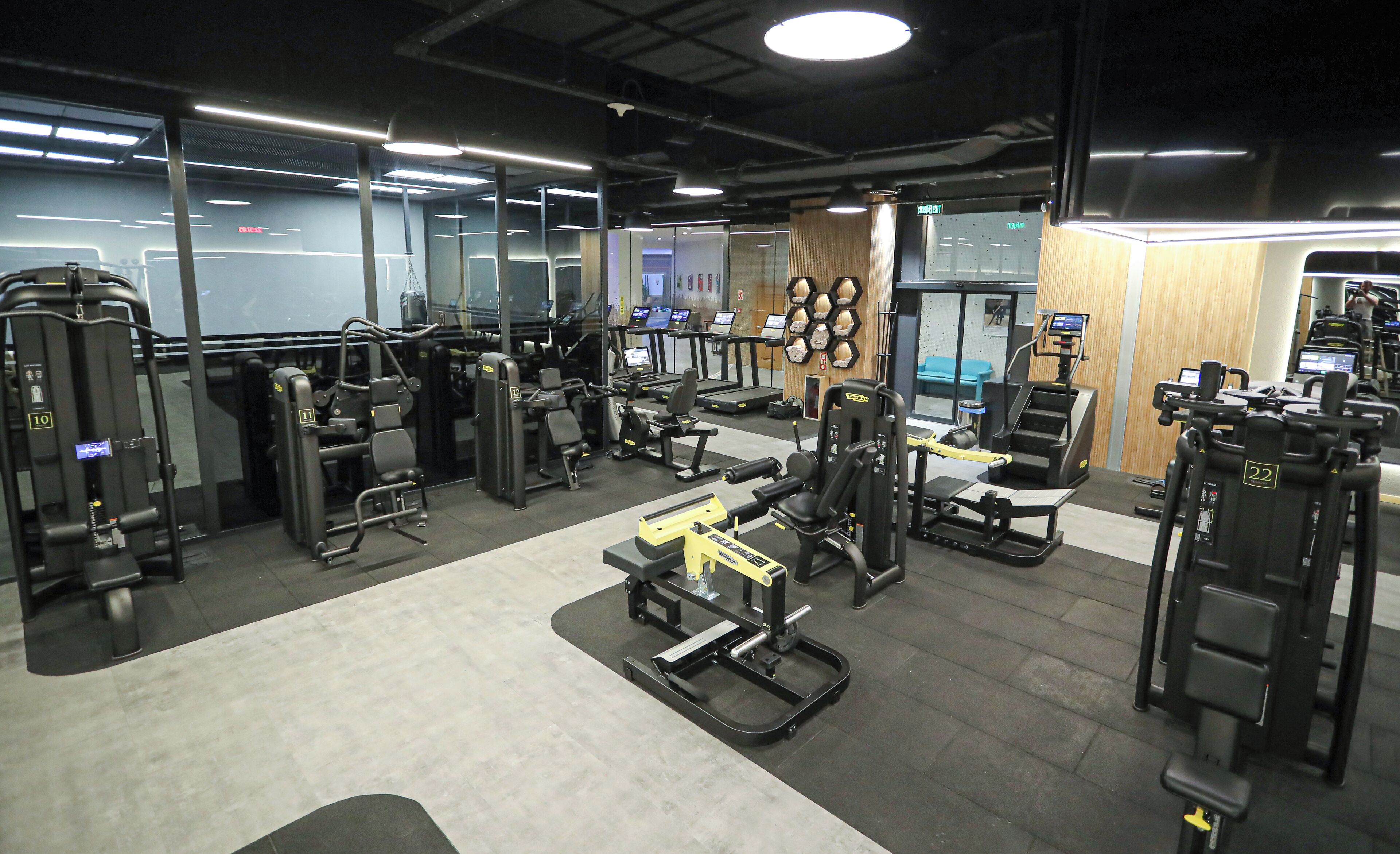 Un gimnasio con diferentes máquinas de ejercicio, cintas de correr y equipo de levantamiento de pesas.