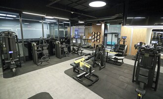 Un gimnasio con diferentes máquinas de ejercicio, cintas de correr y equipo de levantamiento de pesas.