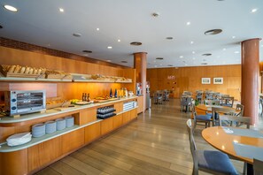 A modern breakfast bar with a built-in oven, a variety of food items, and a seating area with tables and chairs. - Hotel Posadas de España Málaga (Málaga)