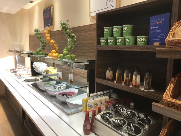 A buffet area with various food items, condiments, and utensils. - Holiday Inn Express Southampton M27 Jct7 by IHG (Southampton)