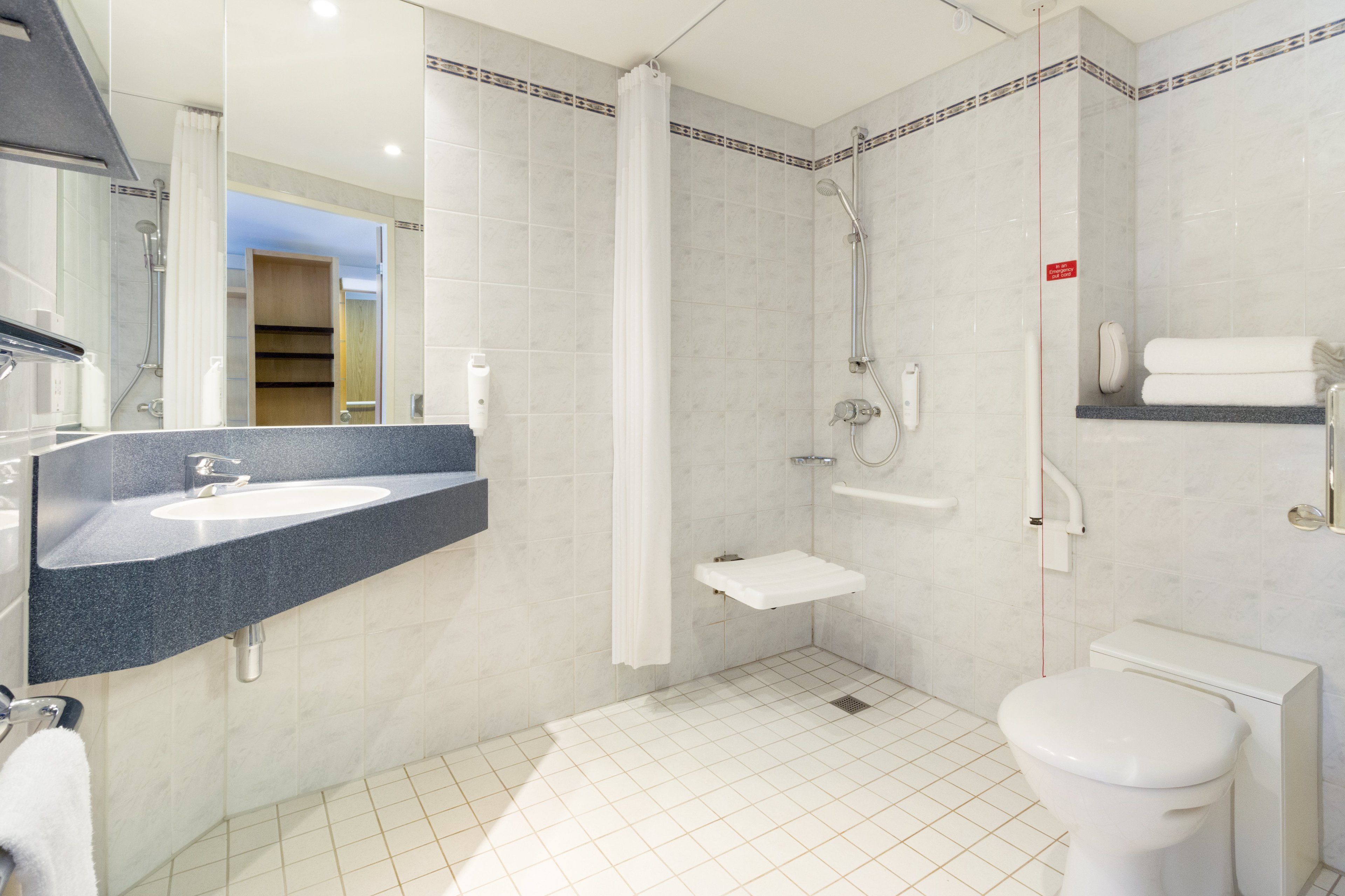 Un bagno moderno con lavabo, water e doccia.