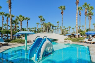 Una piscina techada, una piscina al aire libre, sombrillas