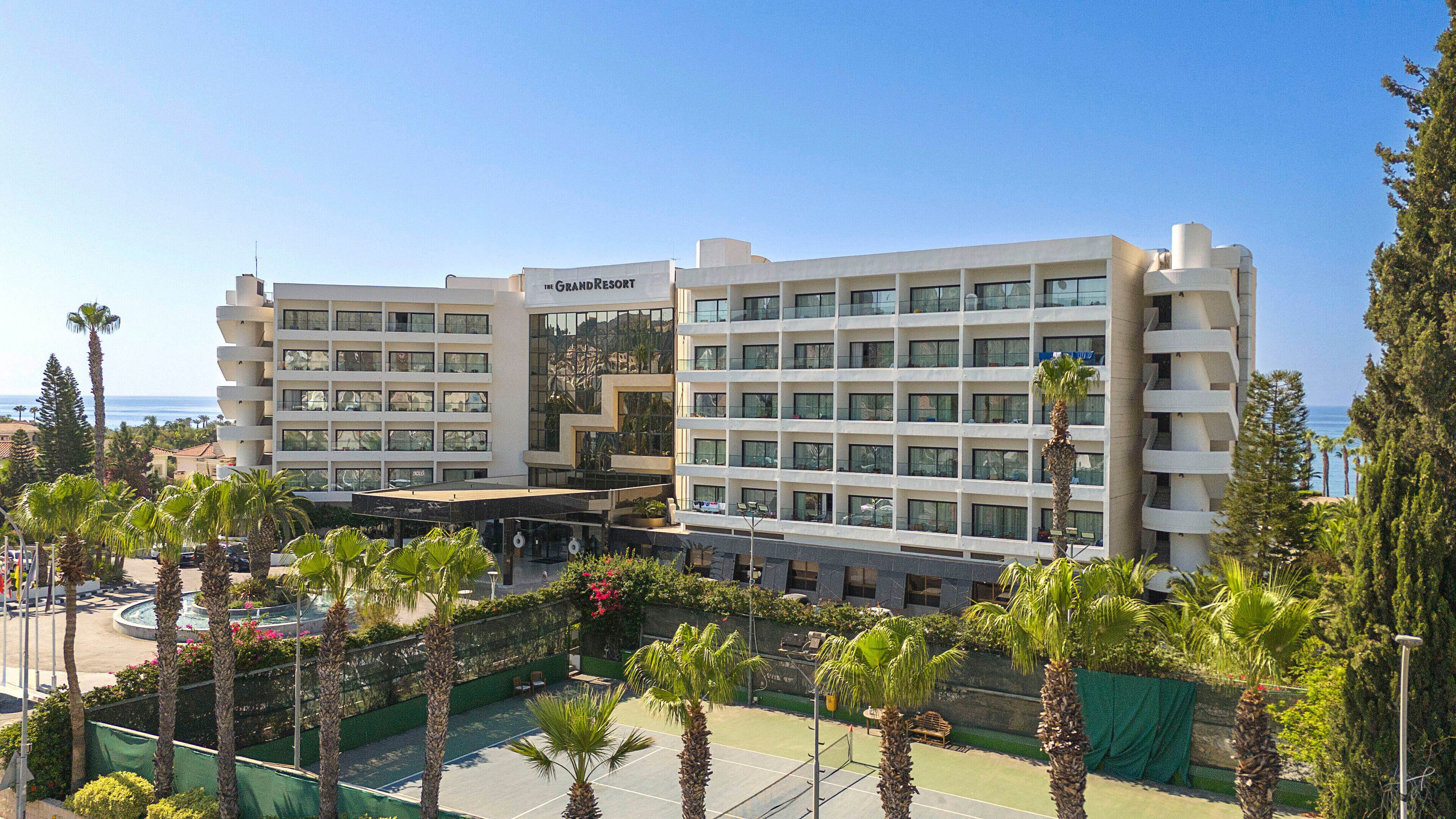 A multi-story hotel with a modern design, featuring balconies and large windows.
