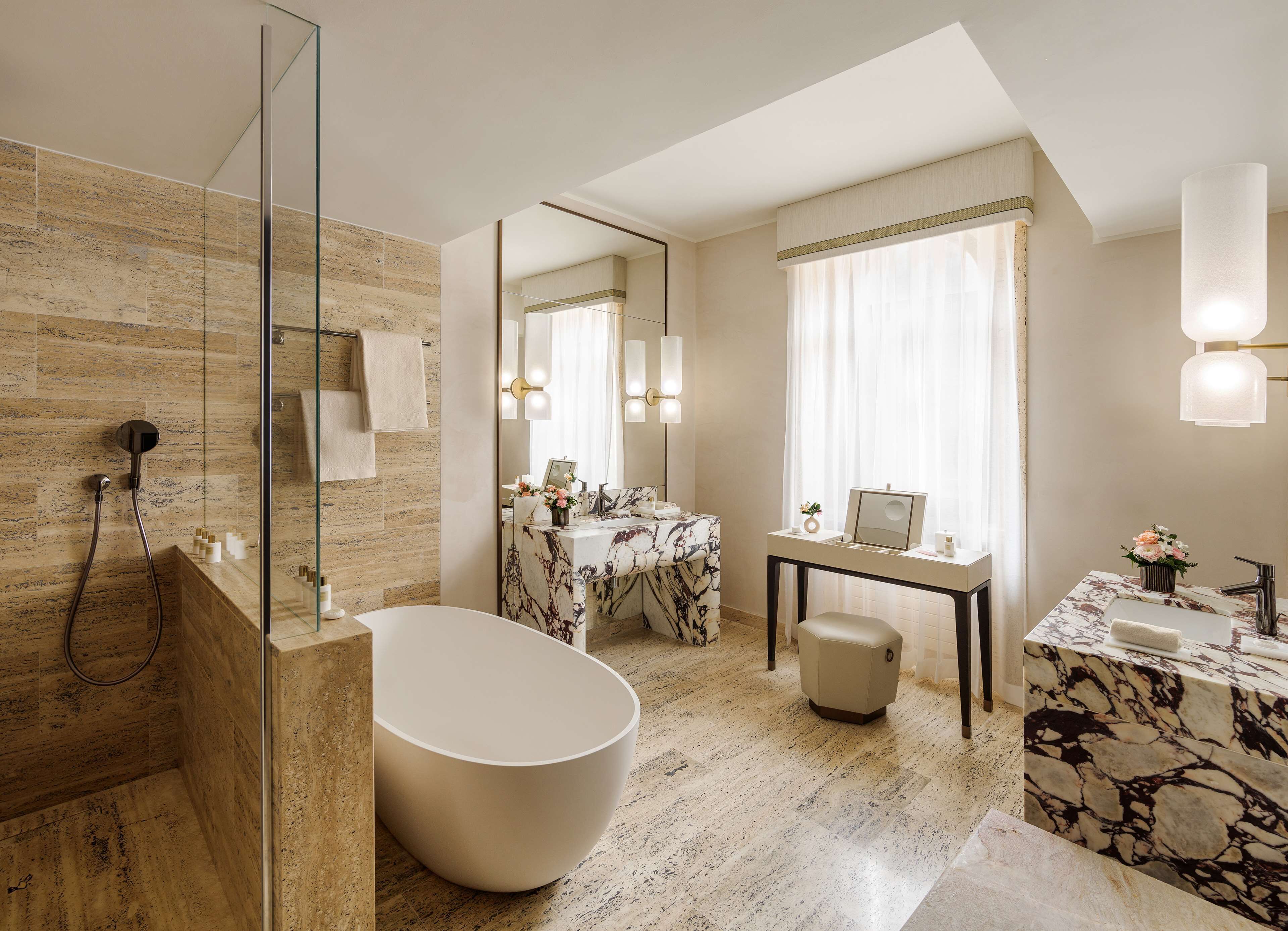 A modern bathroom with a freestanding bathtub, a vanity with a marble countertop, and a large mirror.