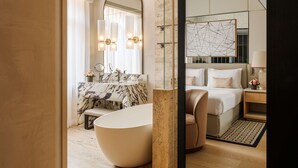 A modern bathroom with a freestanding bathtub, a large mirror, and a vanity with a marble countertop. - Park Hyatt Milano (Milan)