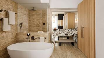 A modern bathroom with a freestanding bathtub, a glass-enclosed shower, and a wooden vanity with a marble countertop.