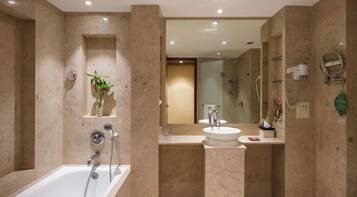 A modern bathroom with a bathtub, a sink, a mirror, and a shower.