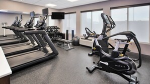 A gym with treadmills, an elliptical, dumbbells, and a TV screen. - Holiday Inn Express & Suites W. Monroe by IHG (West Monroe)