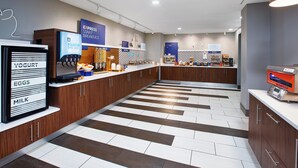 A modern breakfast area with a self-serve station, yogurt, eggs, and milk display, and a sign for express breakfast. - Holiday Inn Express & Suites W. Monroe by IHG (West Monroe)