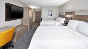 A hotel room with two beds, a desk, a chair, a TV, and a door leading to another room. - Holiday Inn Express & Suites W. Monroe by IHG (West Monroe)