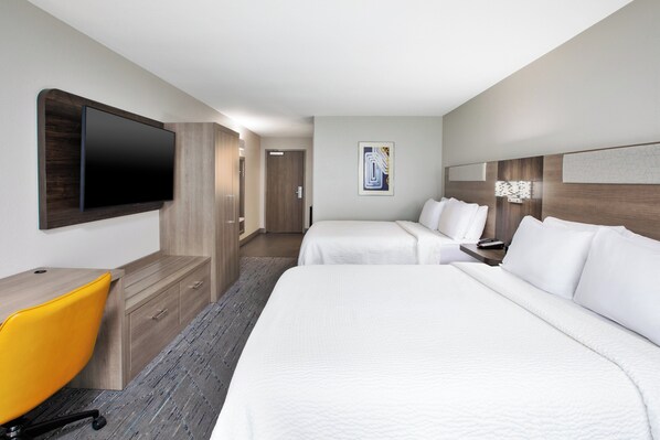 A hotel room with two beds, a desk, a chair, a TV, and a door leading to another room. - Holiday Inn Express & Suites W. Monroe by IHG (West Monroe)