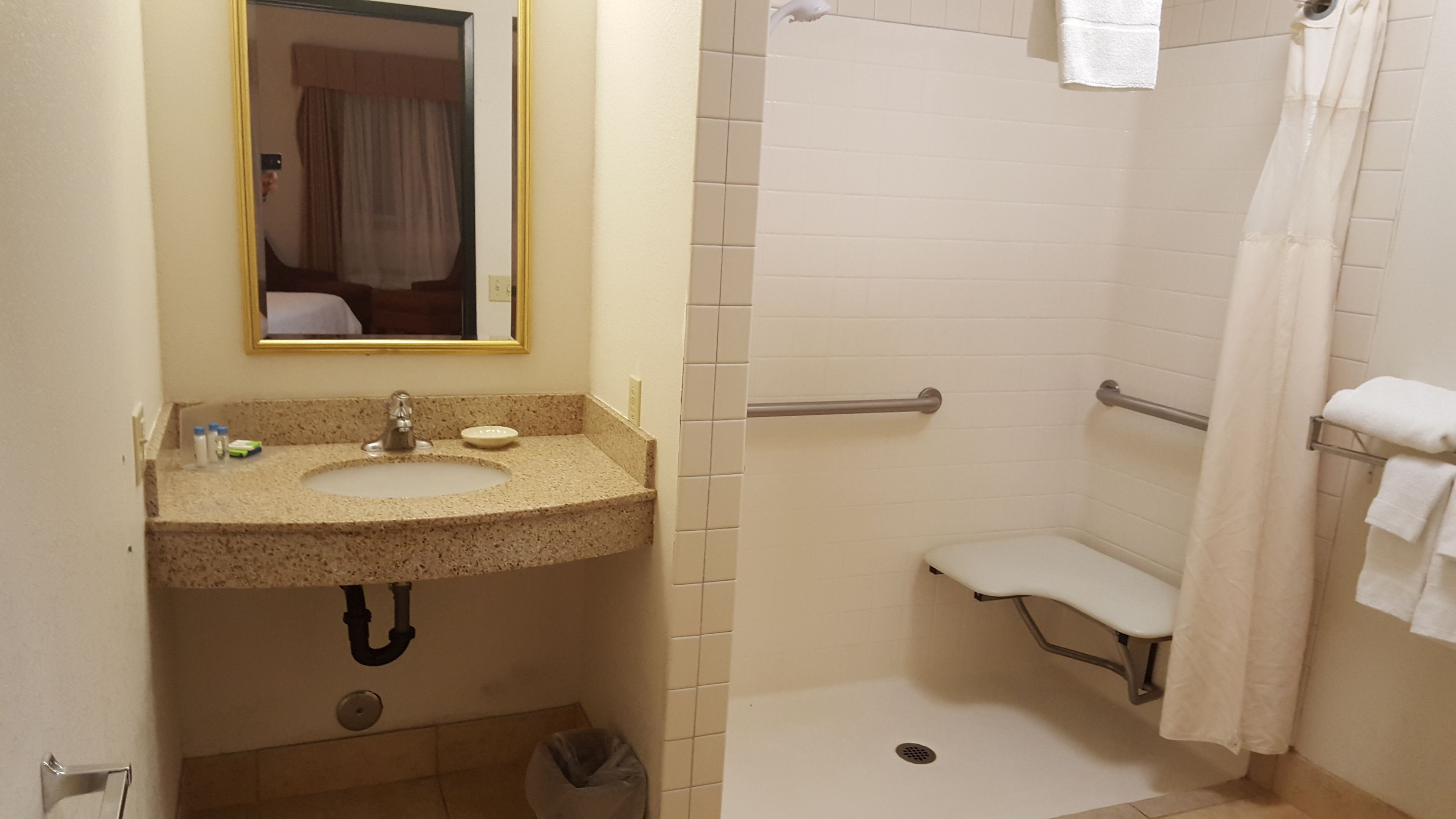 Une salle de bain équipée d’un lavabo, d’un miroir et d’un espace douche.