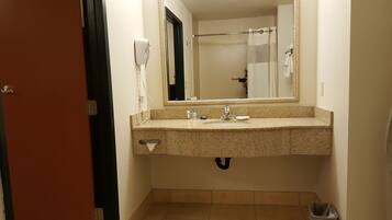 A bathroom with a sink, mirror, towel rack, and a hairdryer on the wall.