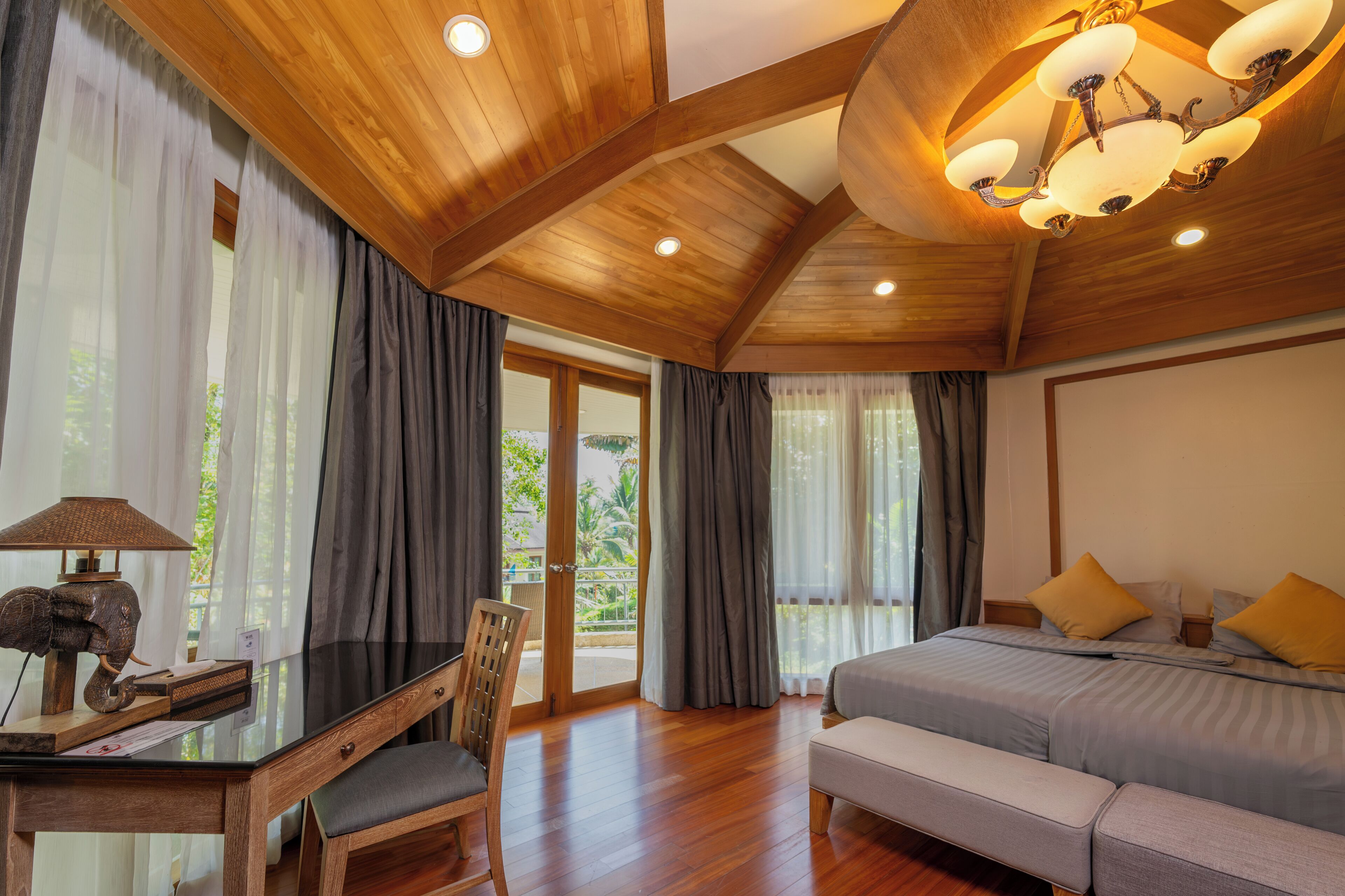 A room with a bed, a desk with a lamp, and a chair.
